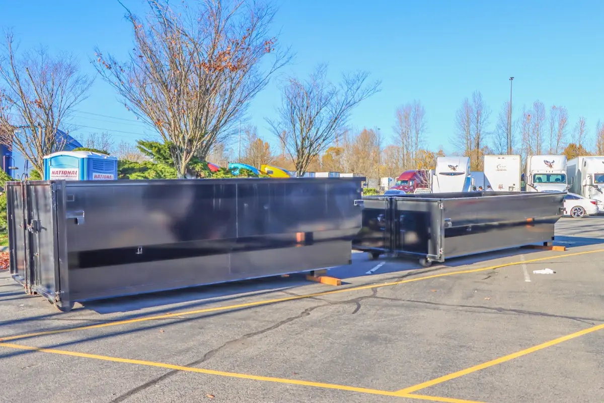Professional dumpster rental service with roll-off container on residential driveway in Freetown
